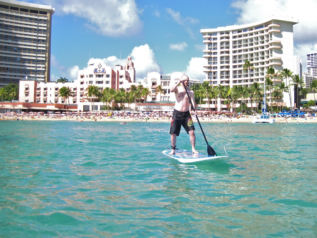 man standing on paddleboard in ocean